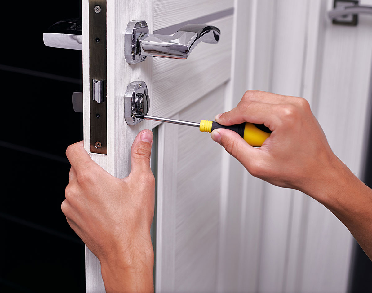 handyman repair the door lock in the room, Man fixing lock with screwdriver, Close-up of repairing door, professional locksmith installing or repairing a new deadbolt lock on a house